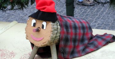 Imagem de tronco de madeira com manta e gorro vermelho