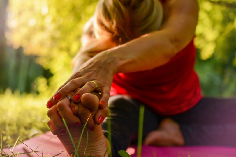 Imagem de mulher praticando ioga ao ar livre