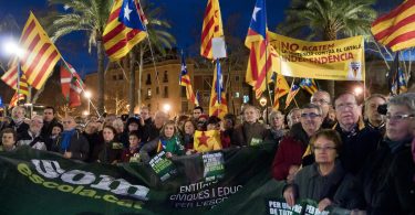 Imagem de grupo de pessoas com bandeiras da Catalunha e lema 'Som escola'