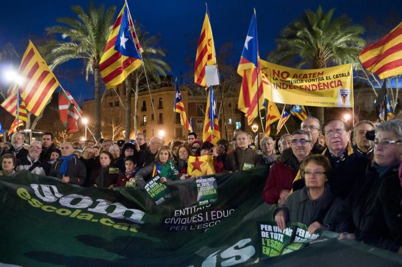 Imagem de grupo de pessoas com bandeiras da Catalunha e lema 'Som escola'