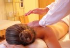 Imagem de mulher deitada de costas, recebendo massagem