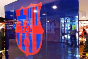 Imagem de porta de vidro com escudo do FC Barcelona