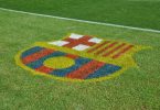 Imagem de escudo do FC Barcelona no gramado
