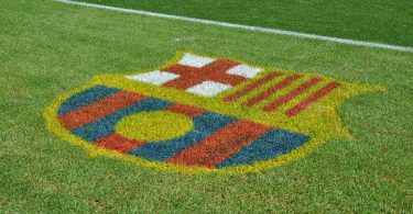 Imagem de escudo do FC Barcelona no gramado