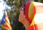 Imagem de mulher com bandeira da Catalunha na cabeça