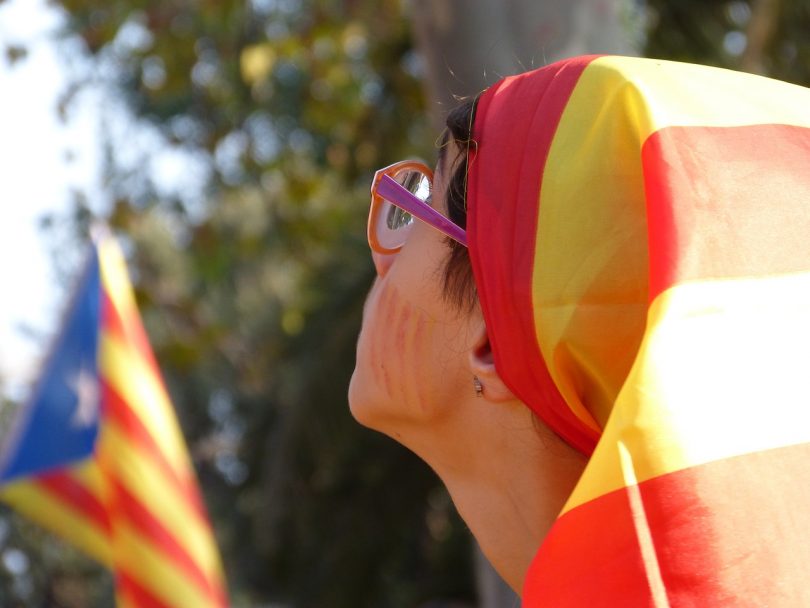 Imagem de mulher com bandeira da Catalunha na cabeça