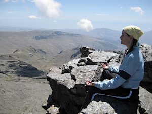 Imagem de mulher praticando meditação na montanha