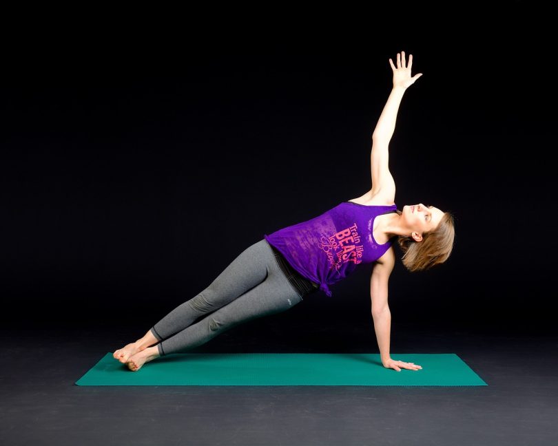 Imagem de mulher esticando o corpo em prática de Pilates