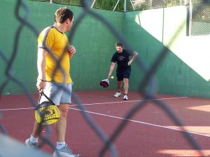 Imagens de homens jogando padel em quadra aberta