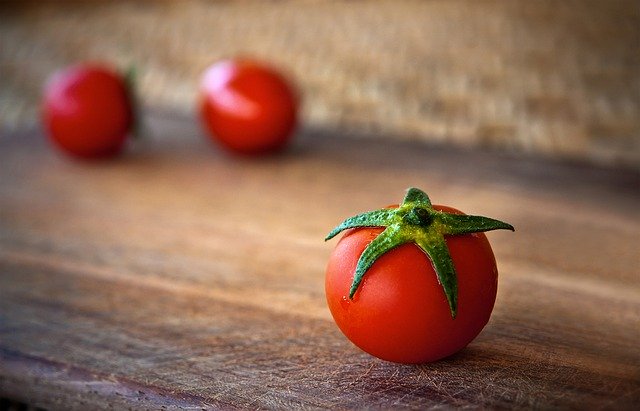 Imagem de um tomate numa mesa de madeira