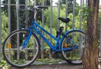 Imagem de uma bicicleta azul encostada em grades