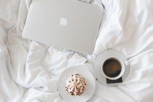 Imagem de laptop e café sobre edredon