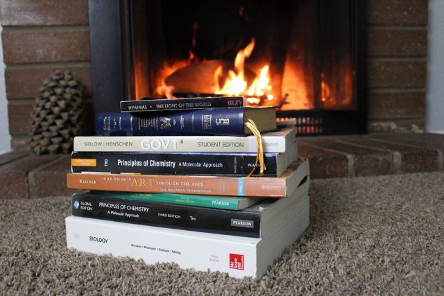 Livros empilhados em frente a uma lareira