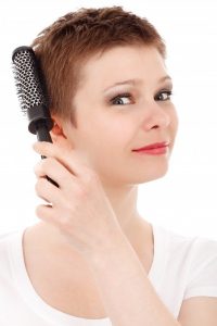 Mulher penteando seu cabelo curto