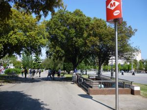 Imagem de Les Corts com pessoas andando próximo à estação do metrô