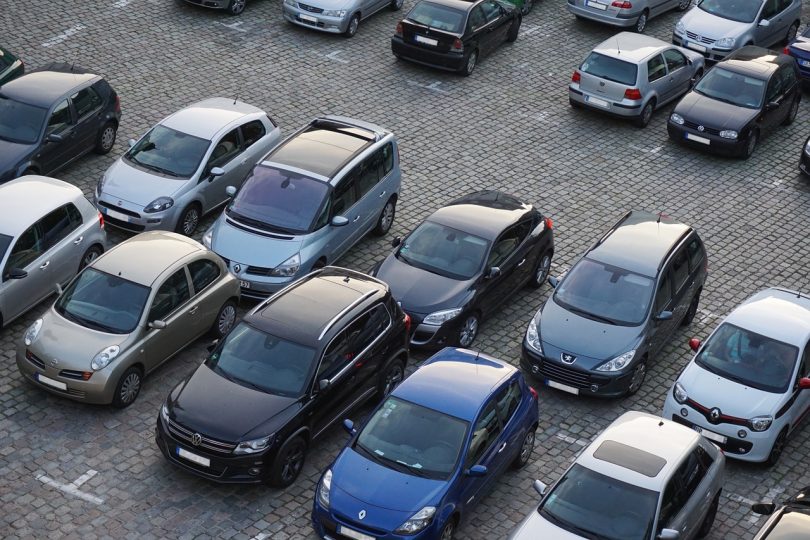 Imagem de carros em fila estacionados em estacionamento a céu aberto
