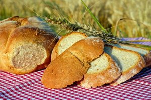 Imagem de lascas grossas de pão sobre toalha de mesa ao ar livre