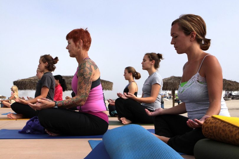 Imagem de mulheres praticando ioga ao ar livre