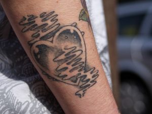Imagem de homem com tatuagem de coração no braço direito