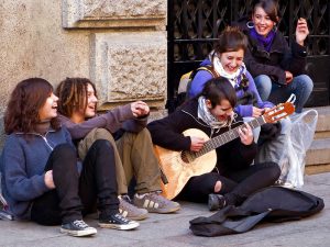 Imagem de jovens sentados em uma calçada em Barcelona