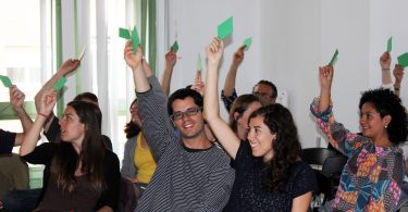 Imagem de pessoas votando em reunião