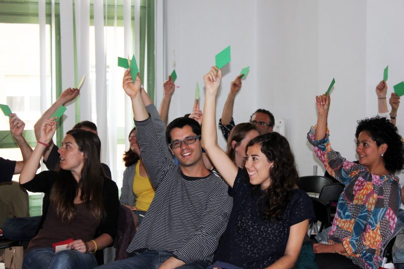 Imagem de pessoas votando em reunião