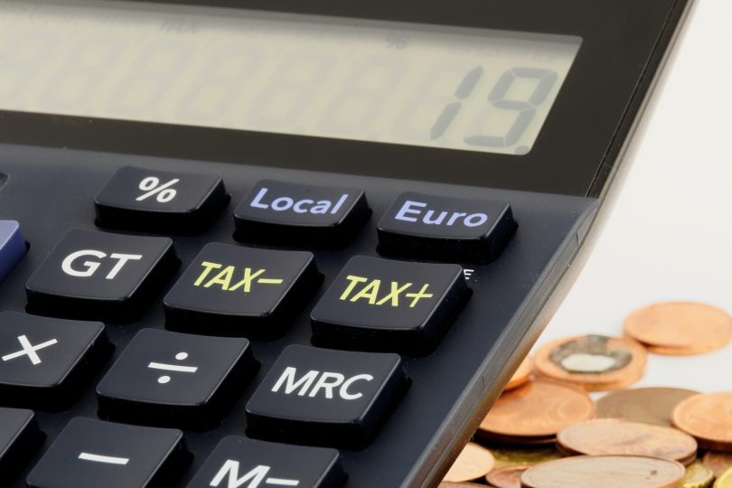 Imagem de uma calculadora perto de moedas