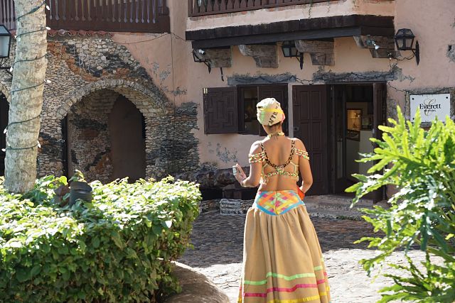 Mulher com roupas que remetem à cultura africana iluminada pelo sol