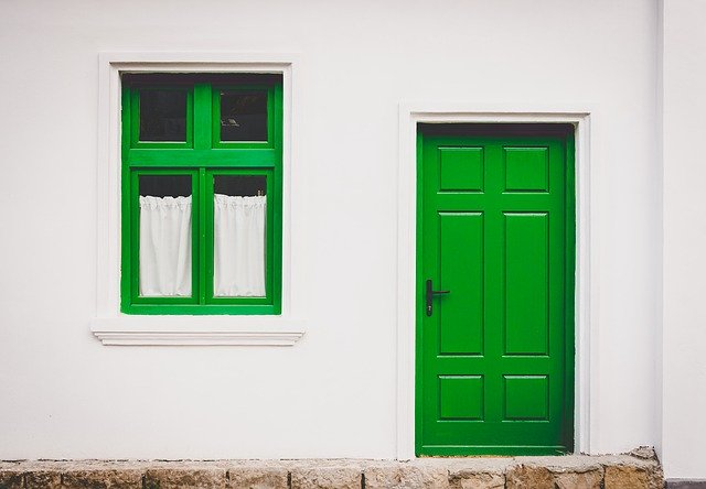 Fachada de uma casa pintada nas cores branco e verde