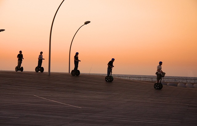 Pessoas andando com o segway à luz do entardecer