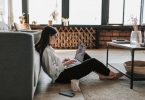 Estudante sentada em seu apartamento com um notebook